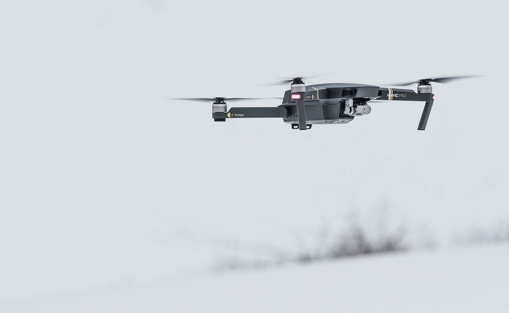Drone autônomo moderno sobrevoando paisagem coberta de neve, símbolo da guerra algorítmica com drones autônomos em 2026