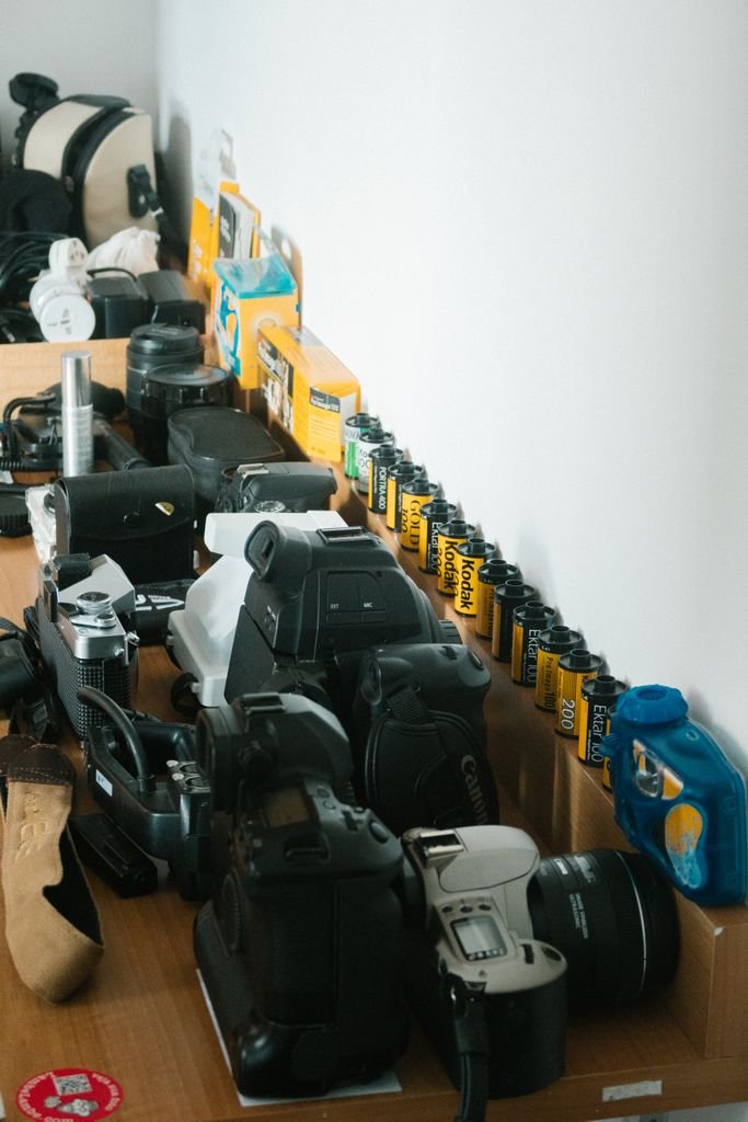 Câmeras vintage e rolos de filme organizados em uma prateleira, simbolizando a história por trás do blog da FOTO FÃ