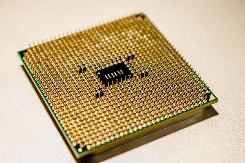 Chip de microprocessador dourado em close-up, representando a corrida por infraestrutura de IA que impulsiona os novos smartphones